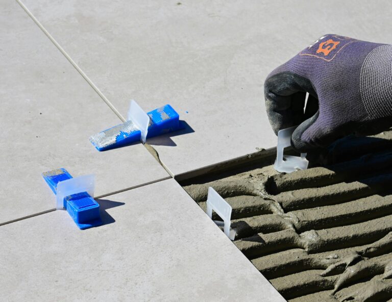 Close-up of professional tile installation using spacers and levelers for perfect alignment.