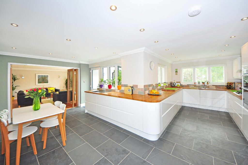 A spacious modern kitchen with elegant interiors featuring a dining table and luxurious design.